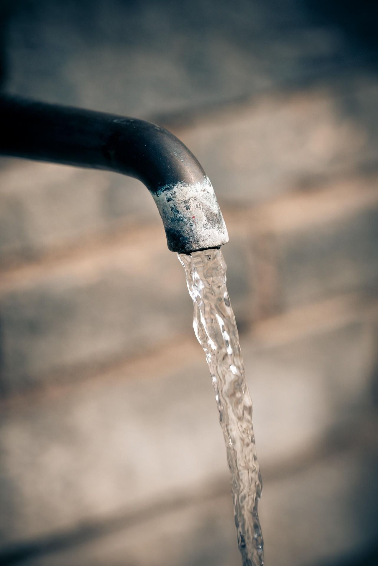 Nahaufnahme eines Wasserhahns mit fließendem Wasser.