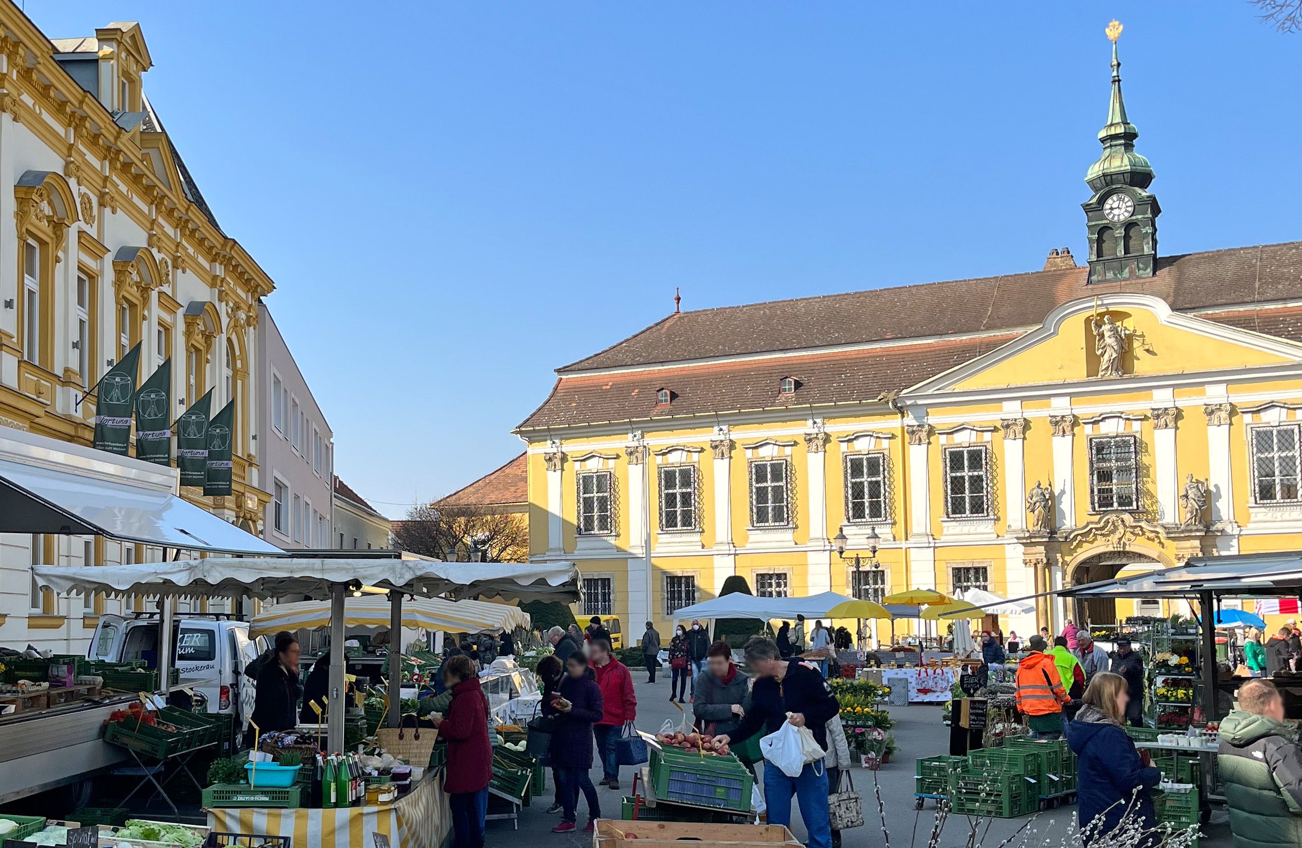 Wochenmarkt in Stockerau mit historischen Gebäuden im Hintergrund.