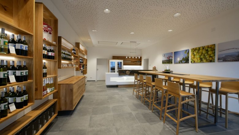 Moderner Verkostungsraum mit Holzmöbeln und Weinregalen.