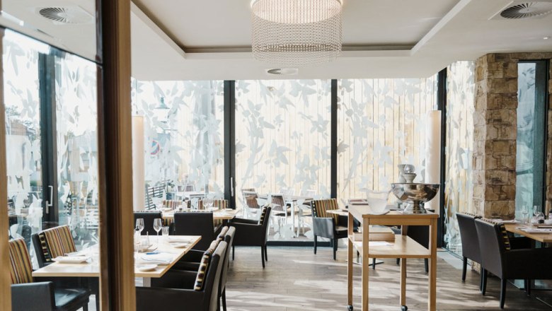 Modernes Restaurant mit großen Fenstern und eleganter Einrichtung.