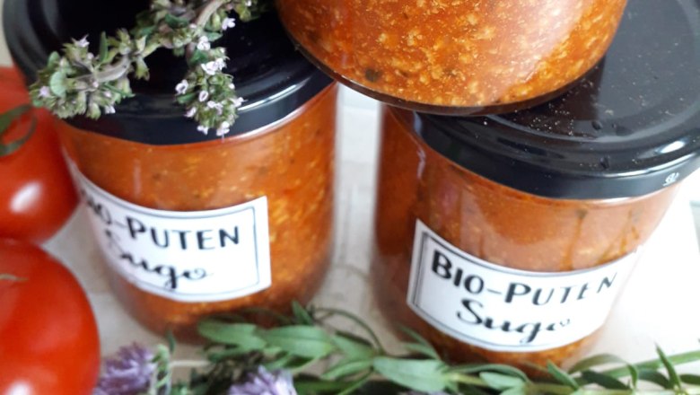 Gl&auml;ser mit Bio-Puten Sugo, daneben Tomaten und Kr&auml;uter.