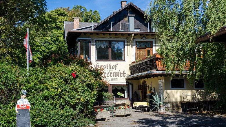 Gasthof Scherrerwirt mit Terrasse und grüner Umgebung.