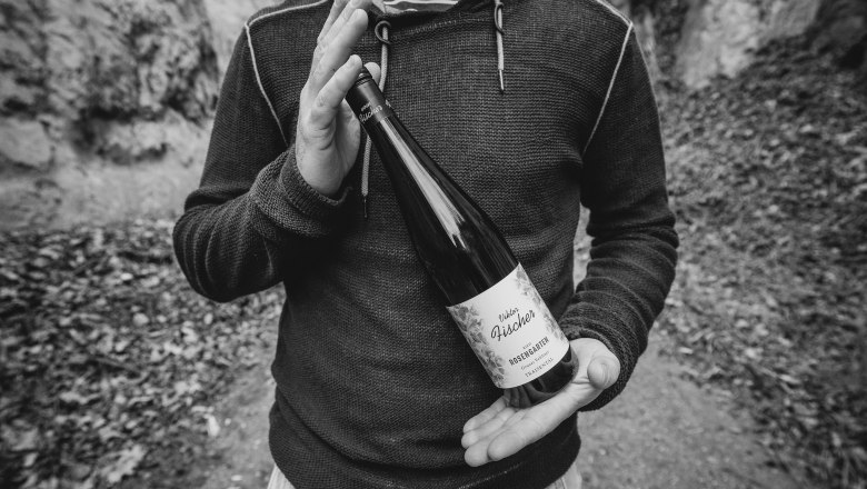 Winzer pr&auml;sentiert Weinflasche