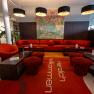 Moderne Hotellobby mit roten M&ouml;beln und Kunstwerk an der Wand.