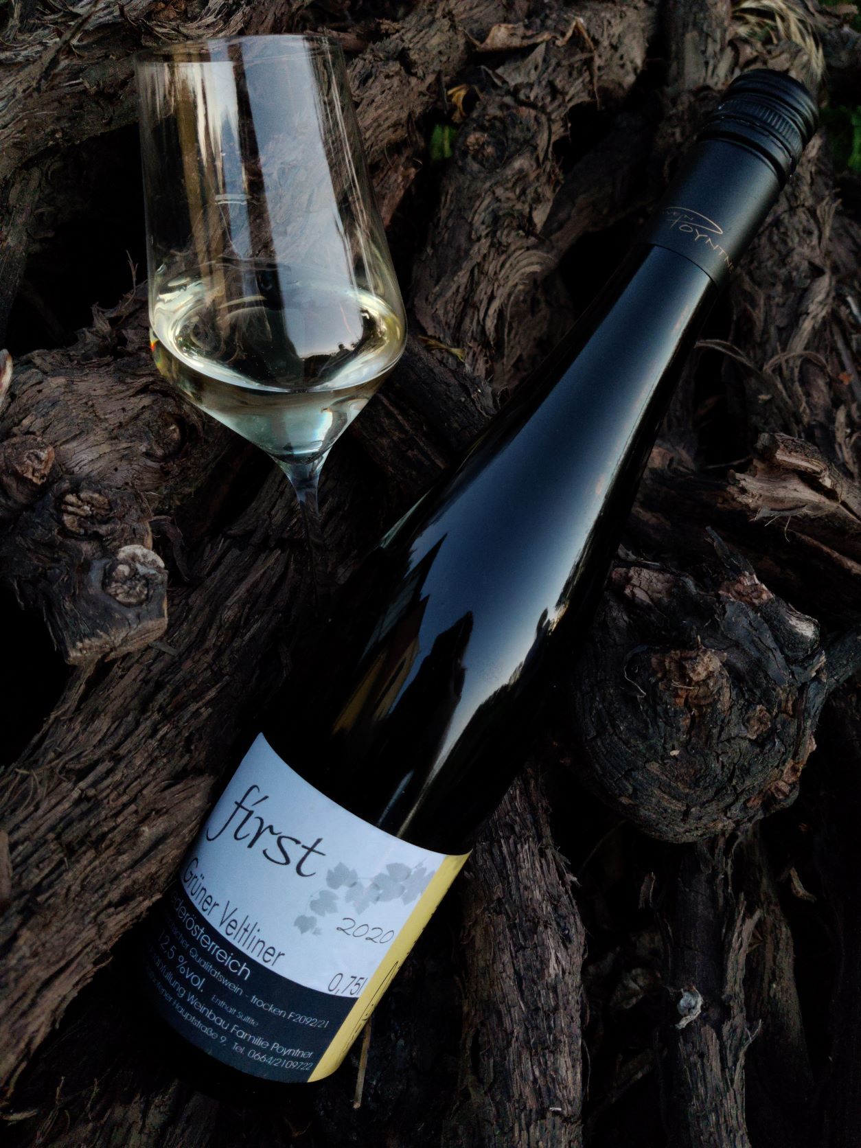 Weinflasche und Glas auf Holz.