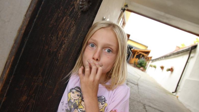 Hereinspaziert, © Fam. Schwalm Ein Mädchen steht in einem Torbogen und schaut überrascht in die Kamera.