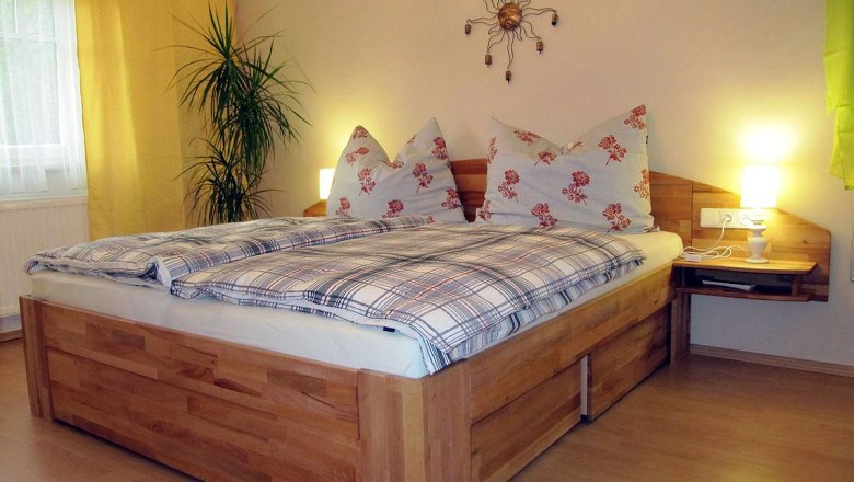 Gästehaus Johanna, © Gästehaus Johanna Gemütliches Schlafzimmer mit Doppelbett, Pflanzen und Wanddekoration.