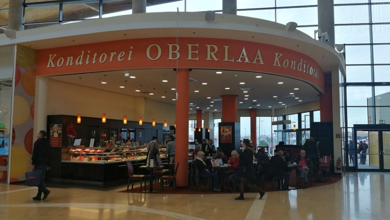 Innenansicht der Konditorei Oberlaa mit G&auml;sten und Theke.