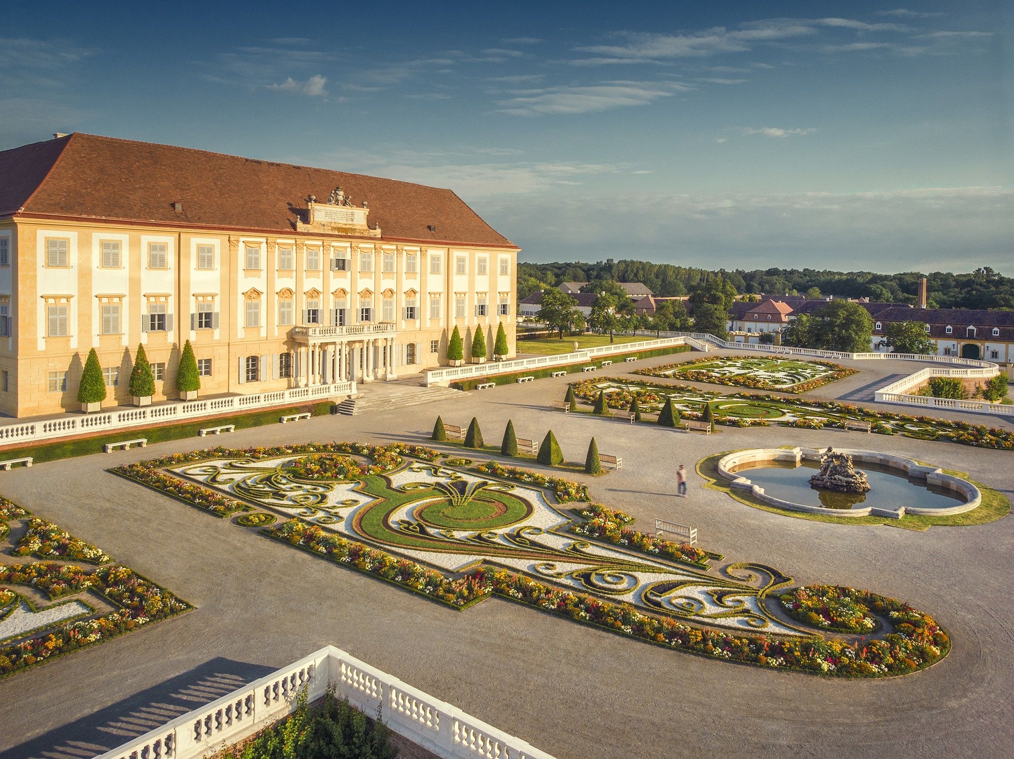 Schloss Hof mit prächtigem Barockgarten und Springbrunnen bei sonnigem Wetter.
