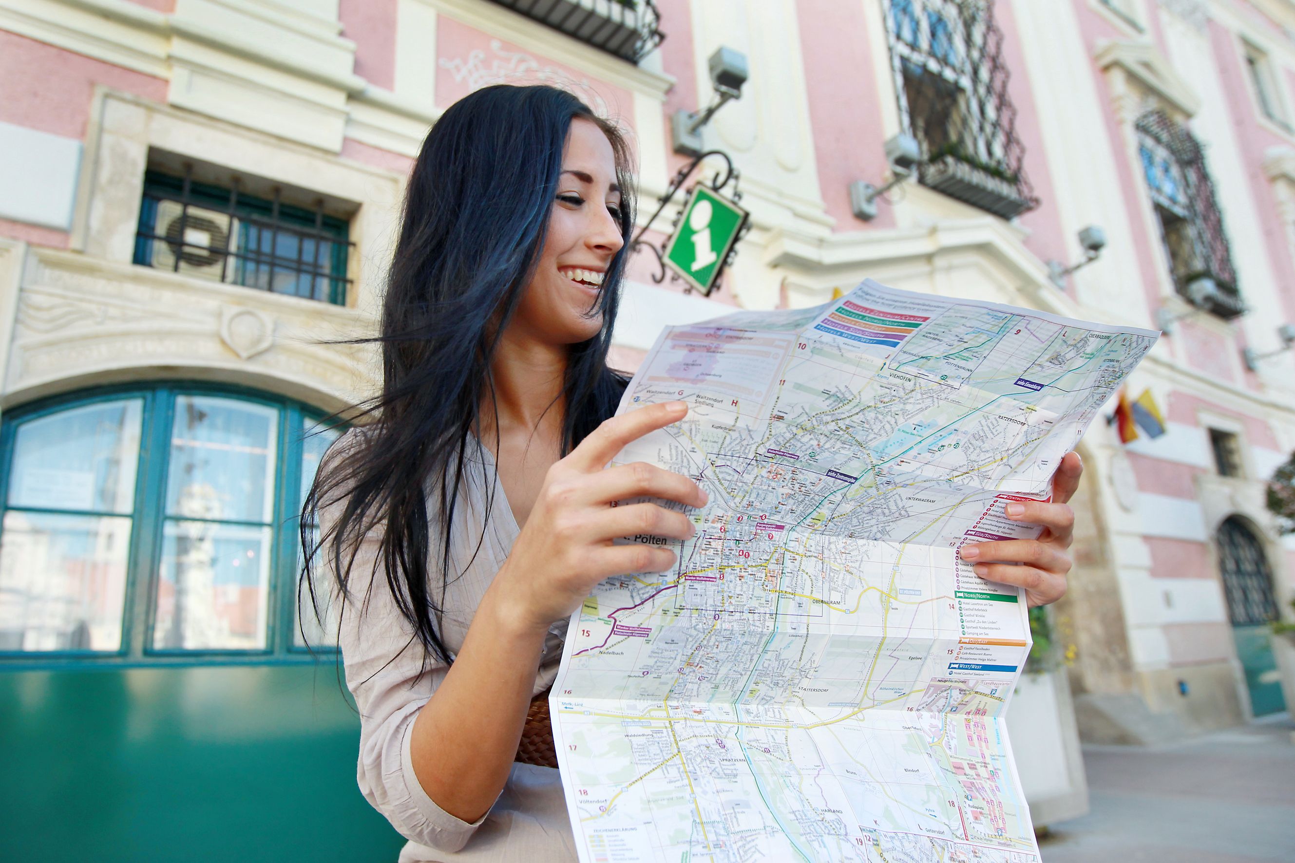 Frau mit Karte vor dem Tourismusbüro St. Pölten.