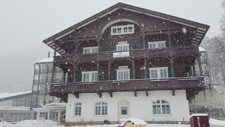 Ein gro&szlig;es, traditionelles Geb&auml;ude im Schnee, beschriftet mit 'Schneeberghof'.