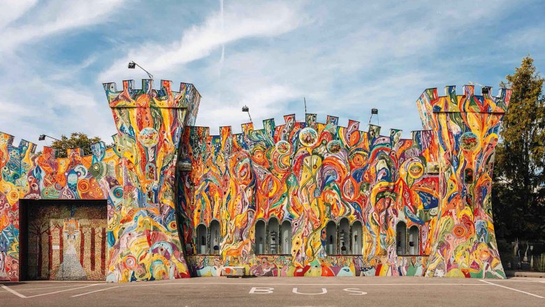 Bunt bemalte Fassade eines Gebäudes in Form einer Burg mit Türmen.