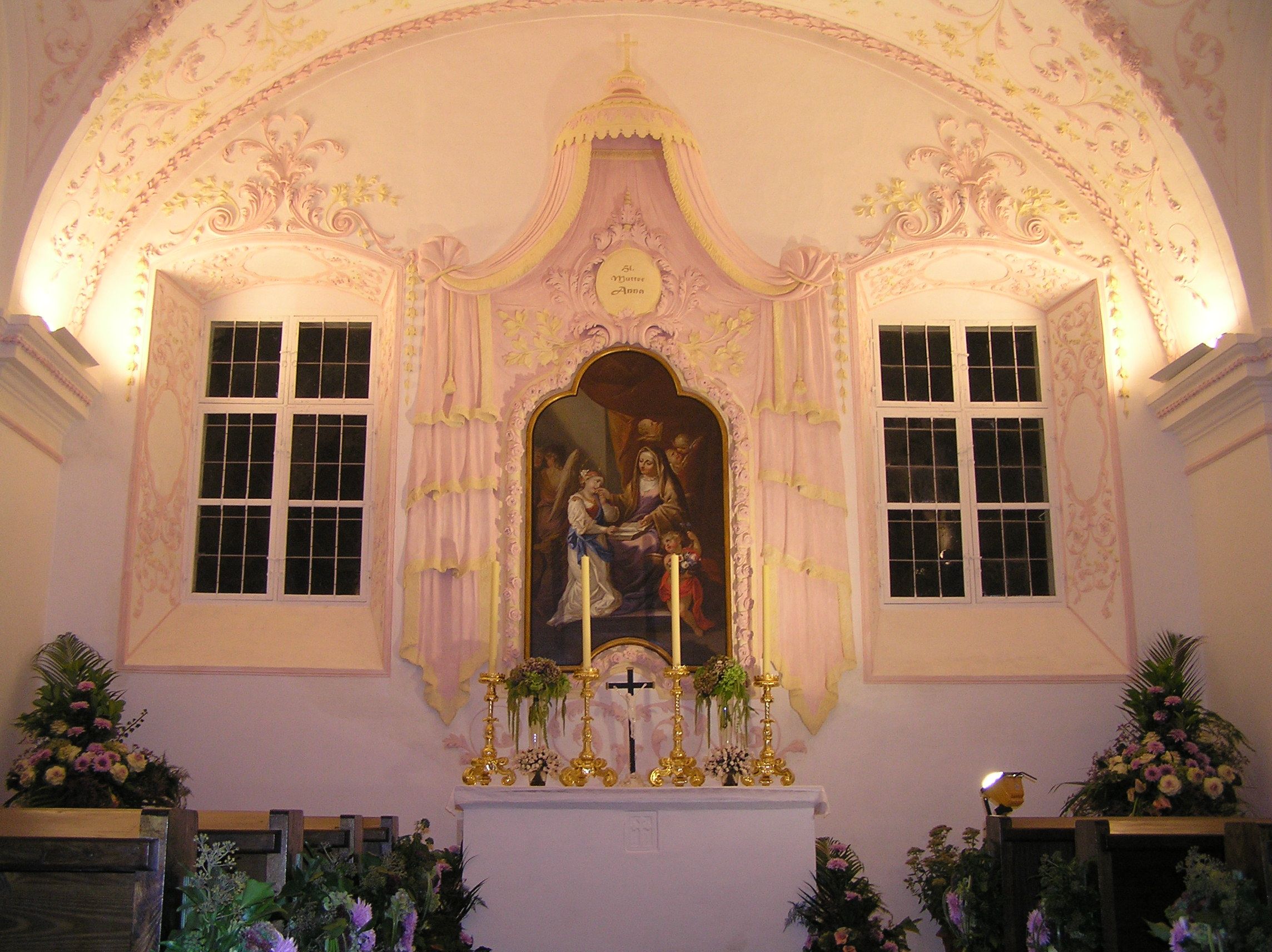 Innenansicht einer Kapelle mit Altar und religiösem Gemälde.