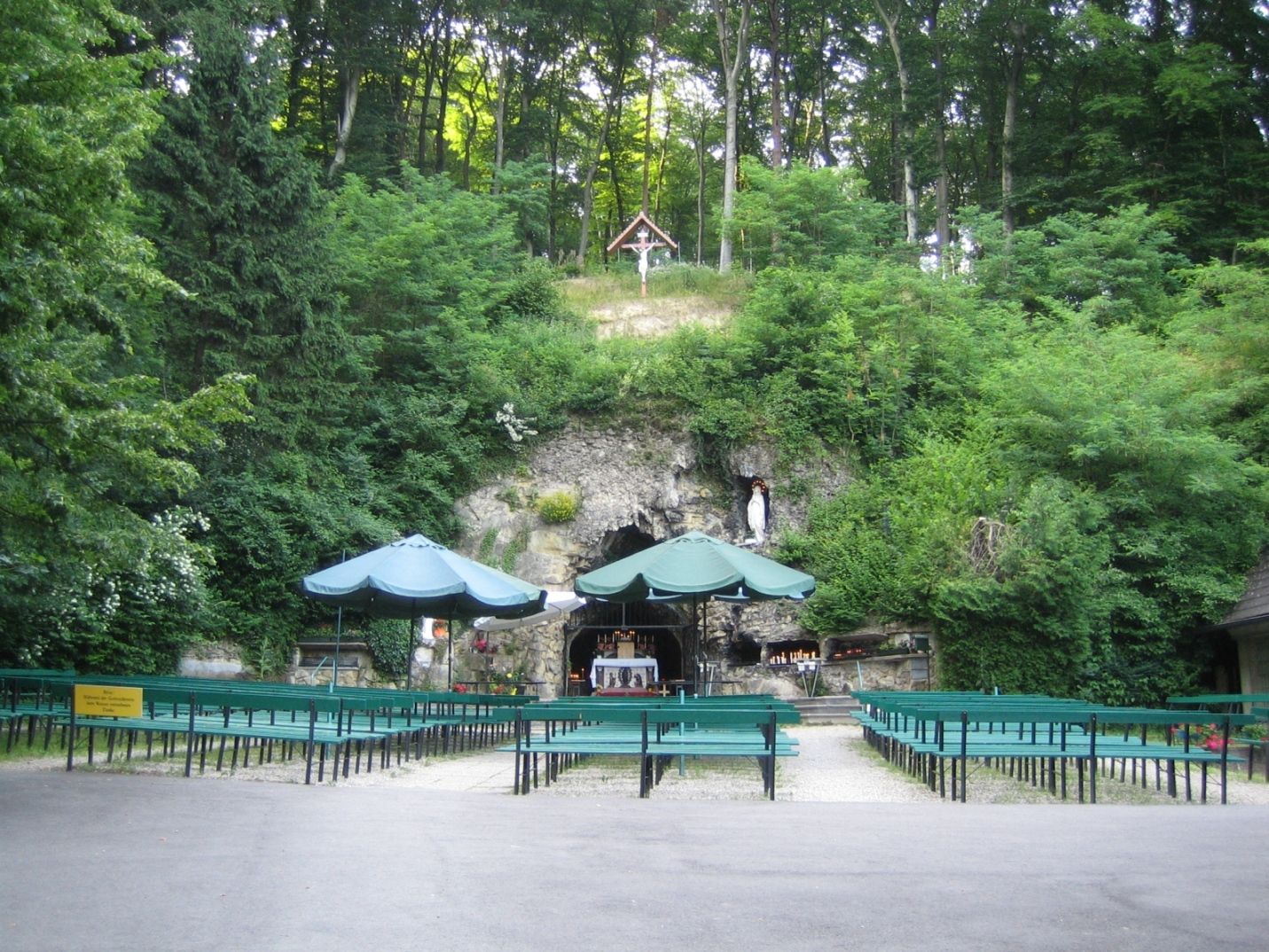 Lourdesgrotte im Wienerwald mit Bänken und grüner Umgebung.