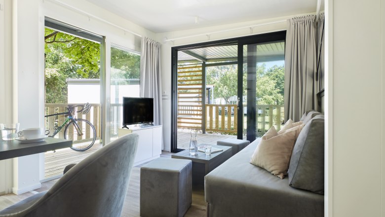 Innenansicht Wohnbereich mit Blick auf die Terrasse ins Grüne