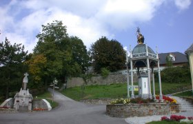 Wallfahrtskirche St. Corona am Schöpfl mit Statue und Pavillon.