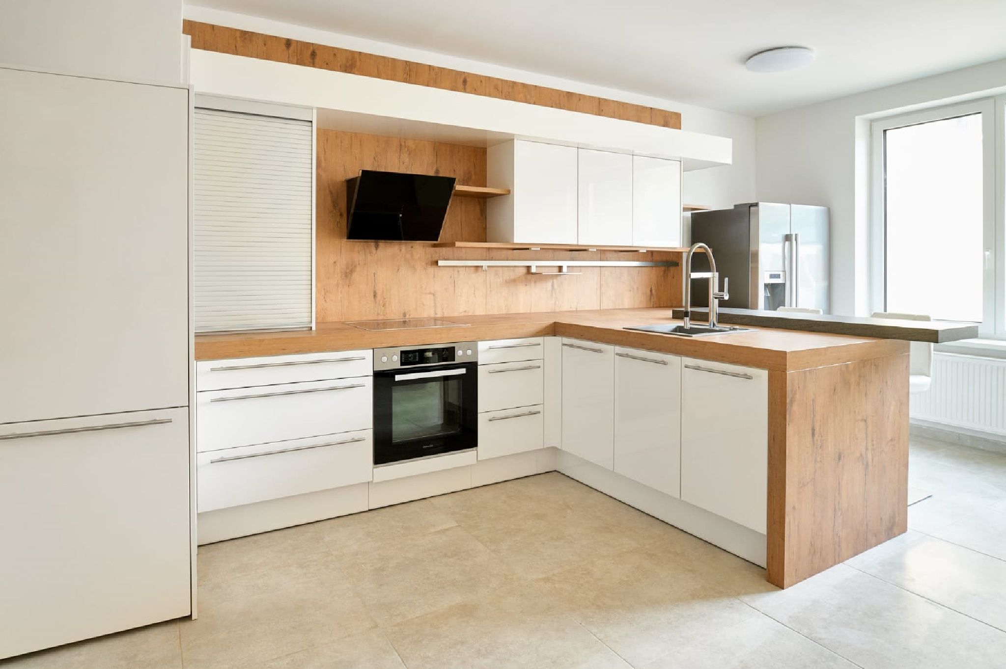 Moderne Küche mit Holz- und Weißtönen, Herd, Spüle und großem Fenster.