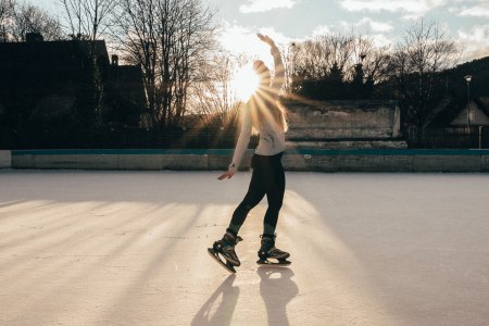 Eisläuferin macht Kunststück auf Eislaufplatz