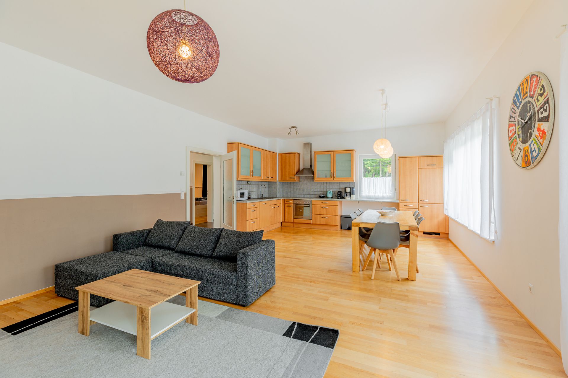 Offener Wohnbereich mit Küche, Esstisch und Sofa.