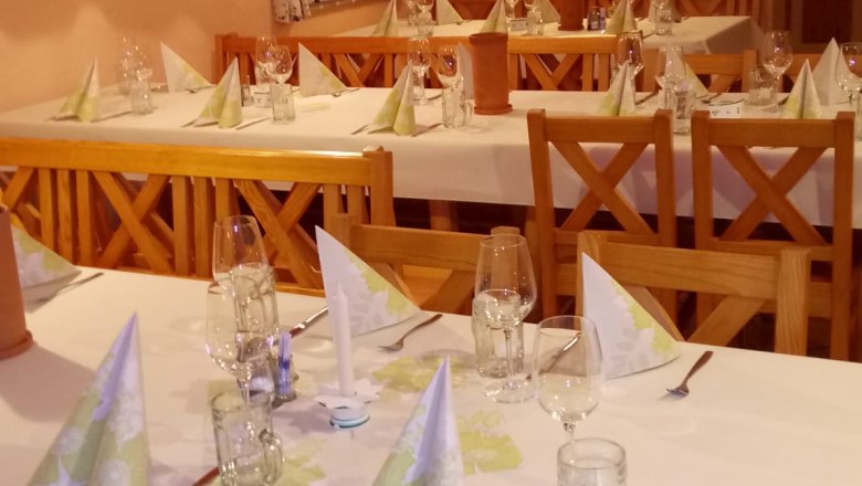 Eingedeckte Tische innen mit wei&szlig;er Tischw&auml;sche