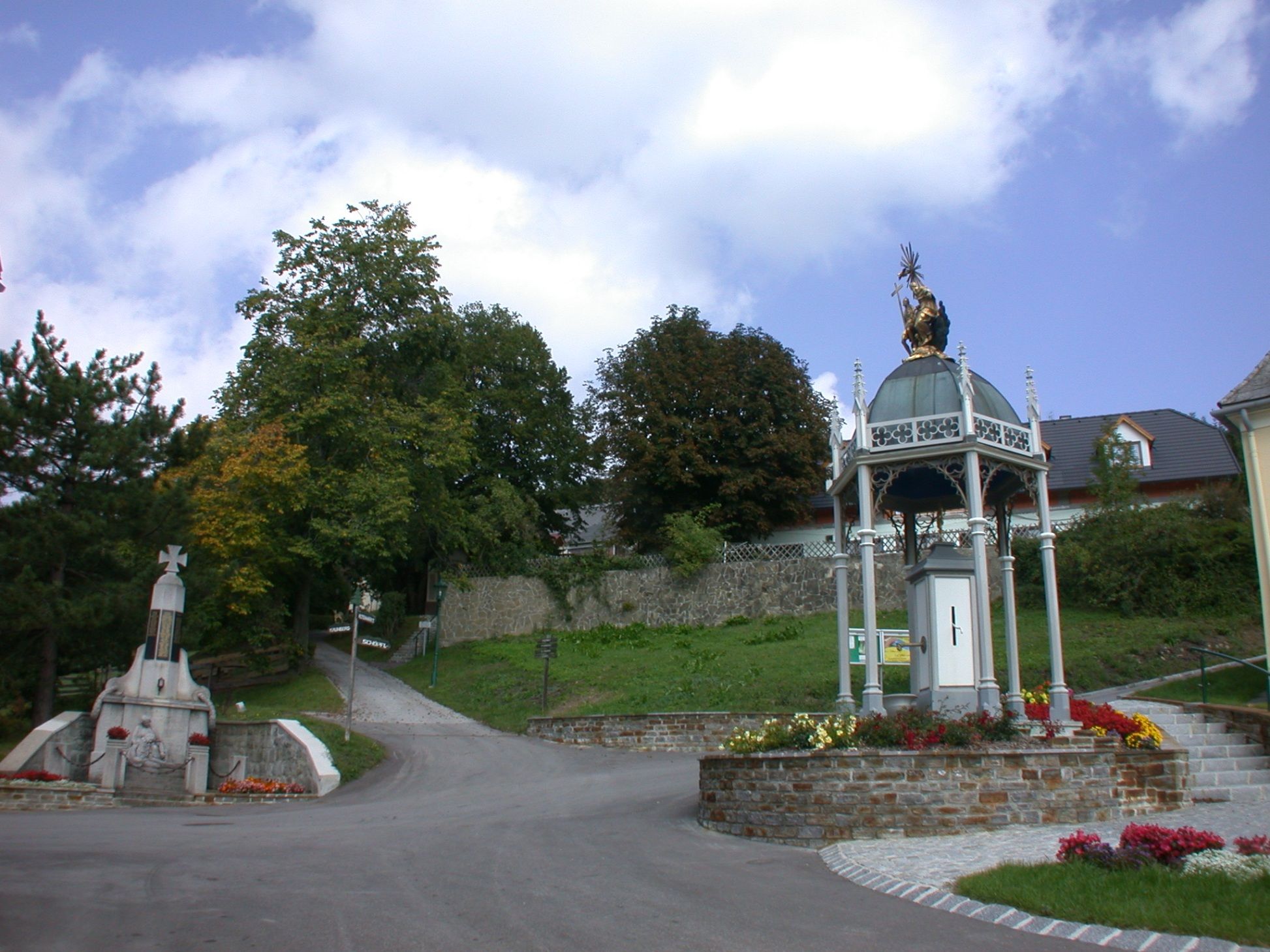 Wallfahrtskirche St. Corona am Schöpfl mit Statue und Pavillon.