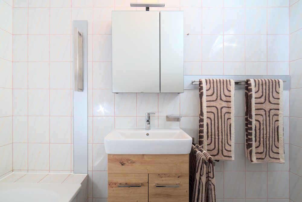 Modernes Badezimmer mit Waschbecken, Spiegel und Handtüchern.