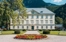 Schloss Reichenau mit Garten und Blumenbeet im Vordergrund.