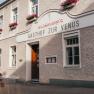 Gasthof zur Venus mit blumengeschmückter Fassade und Holztür.