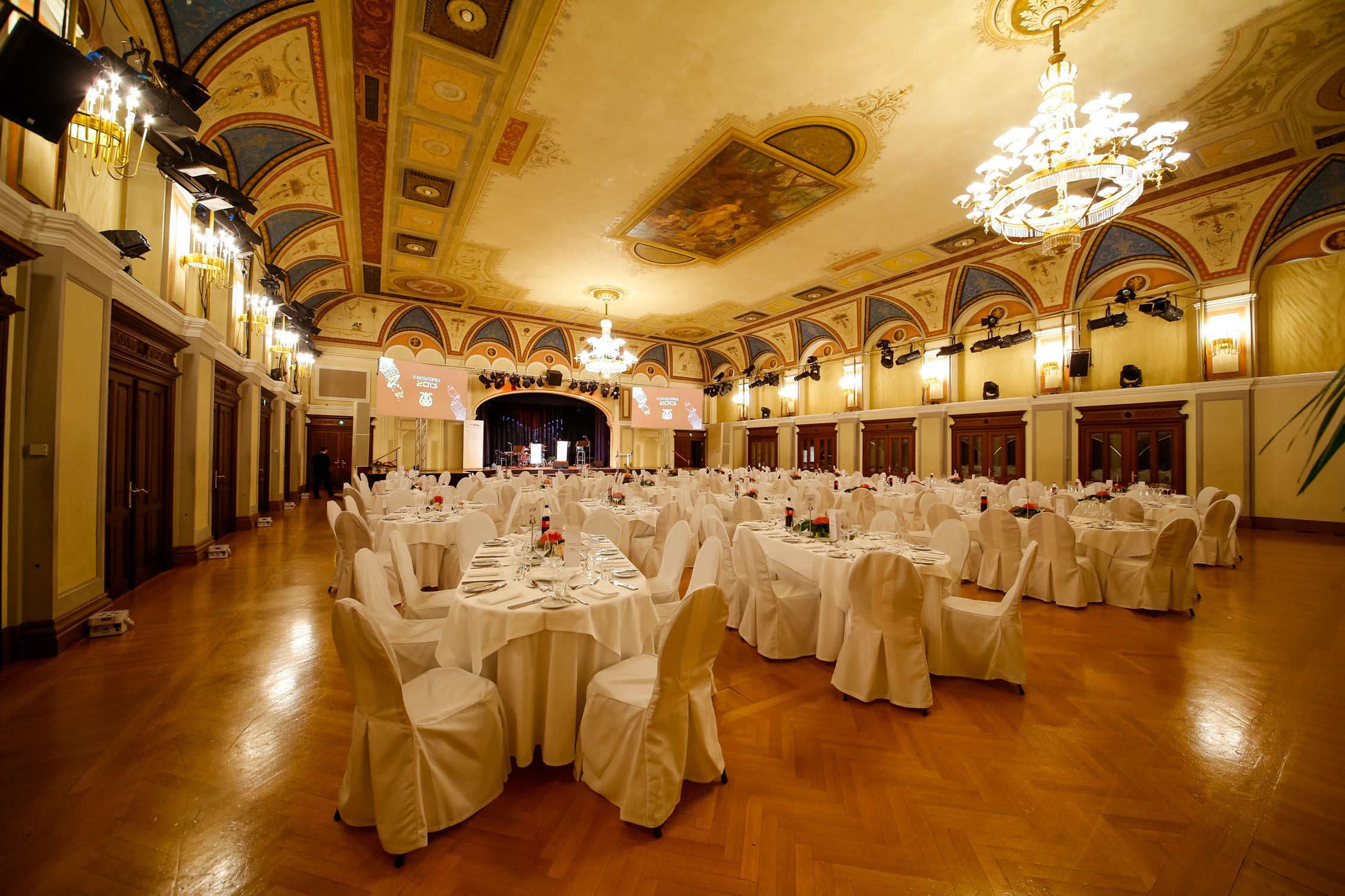 Eleganter Festsaal mit gedeckten Tischen und Kronleuchtern im Congress Center Baden.