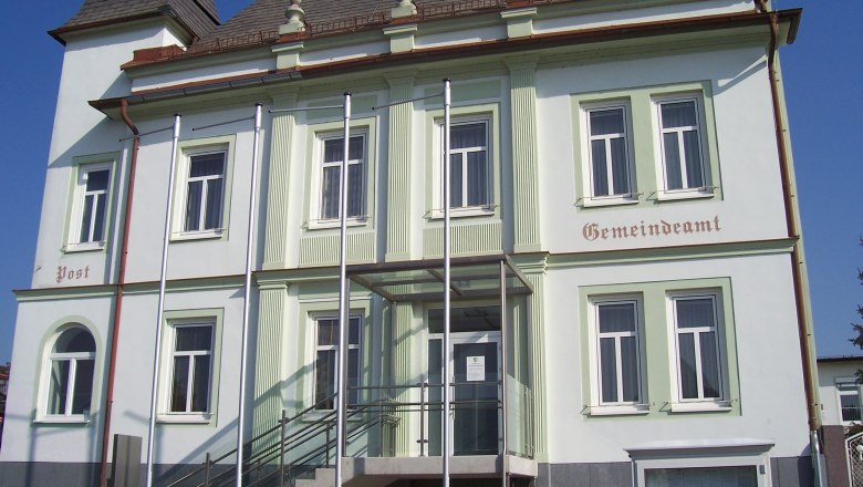 Gemeindeamt Untersiebenbrunn mit Treppe und Fahnenmasten vor dem Geb&auml;ude.