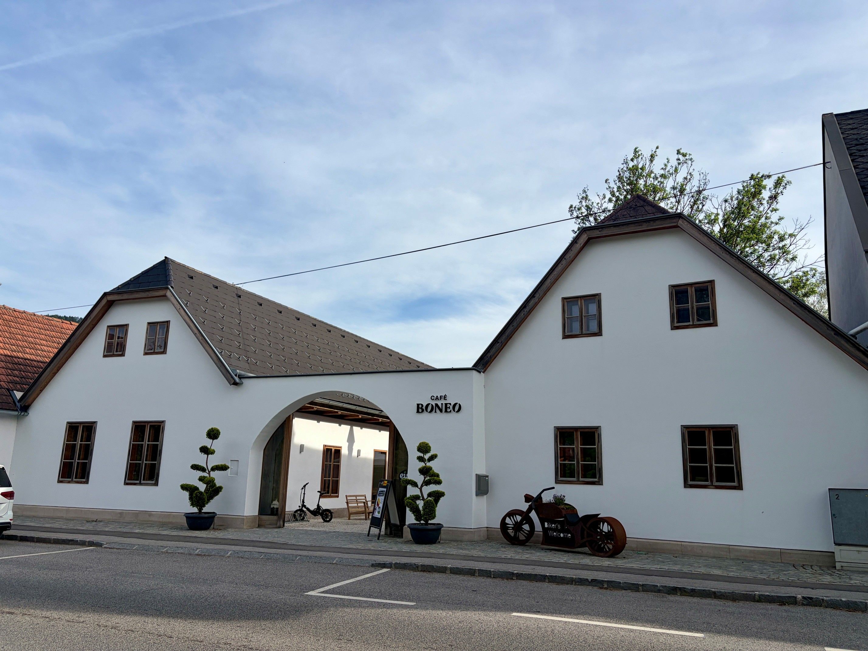 Außenansicht des Cafe Boneo mit weißer Fassade und zwei Giebeln.
