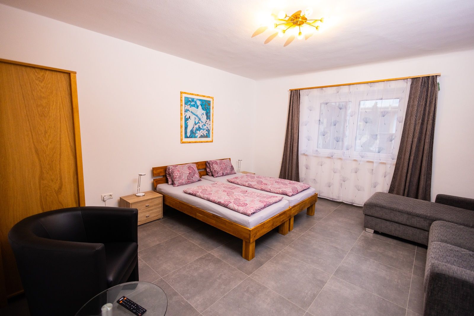 Schlafzimmer mit Doppelbett, Sofa und Sessel.