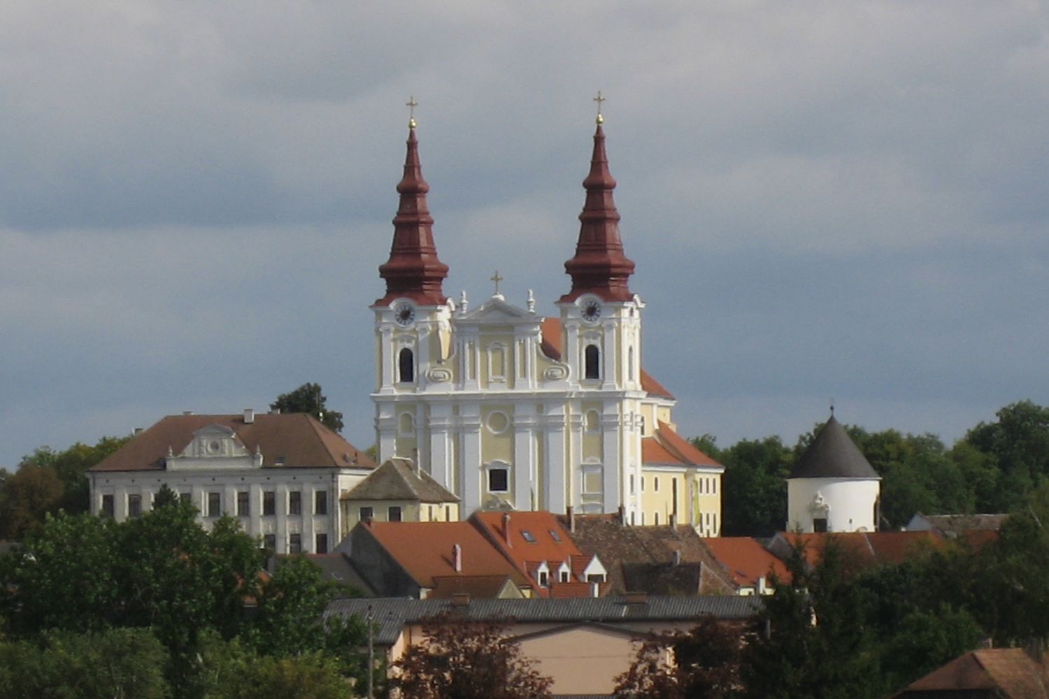 Barockkirche mit zwei Türmen und umliegenden Gebäuden.