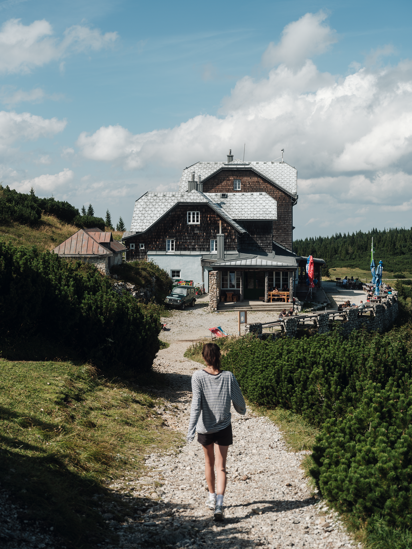 Umgeben von üppigen Wiesen und majestätischen Bergen, lädt die idyllische Hütte zu einer wohlverdienten Rast ein. Die klare Luft und das sanfte Plätschern des Wassers schaffen eine harmonische Atmosphäre, die Wanderer in ihren Bann zieht.