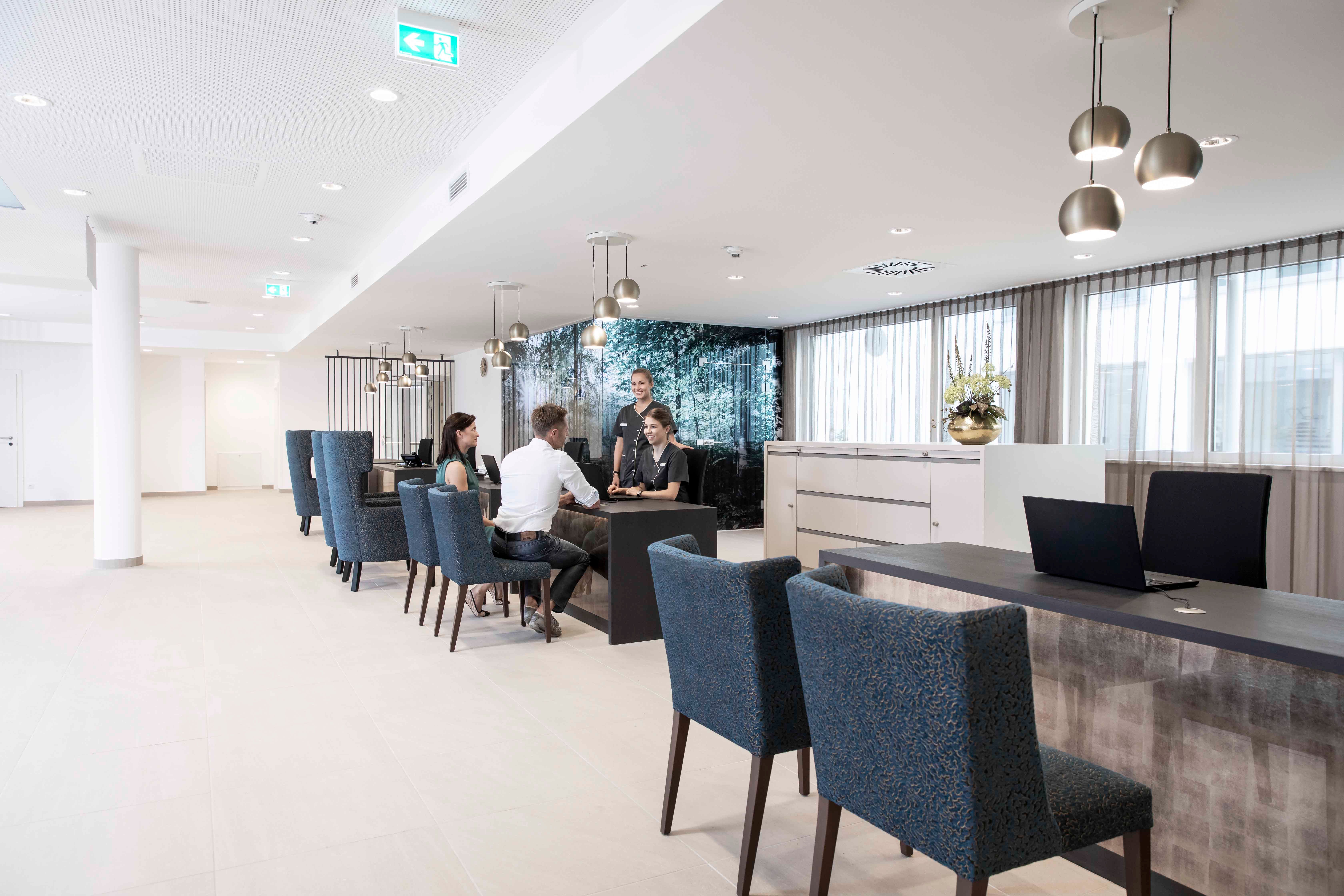 Moderne Rezeption mit Menschen, die an einem Tisch sitzen und sprechen.