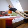 Doppelzimmer Weingut & G&auml;stezimmer Edelmann, Mann springt auf Bett