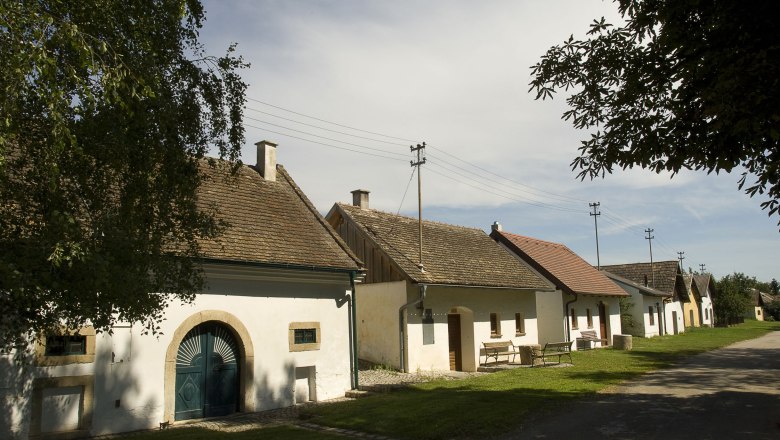 Reihe traditioneller Weinkeller in Grabern, &Ouml;sterreich, bei sonnigem Wetter.