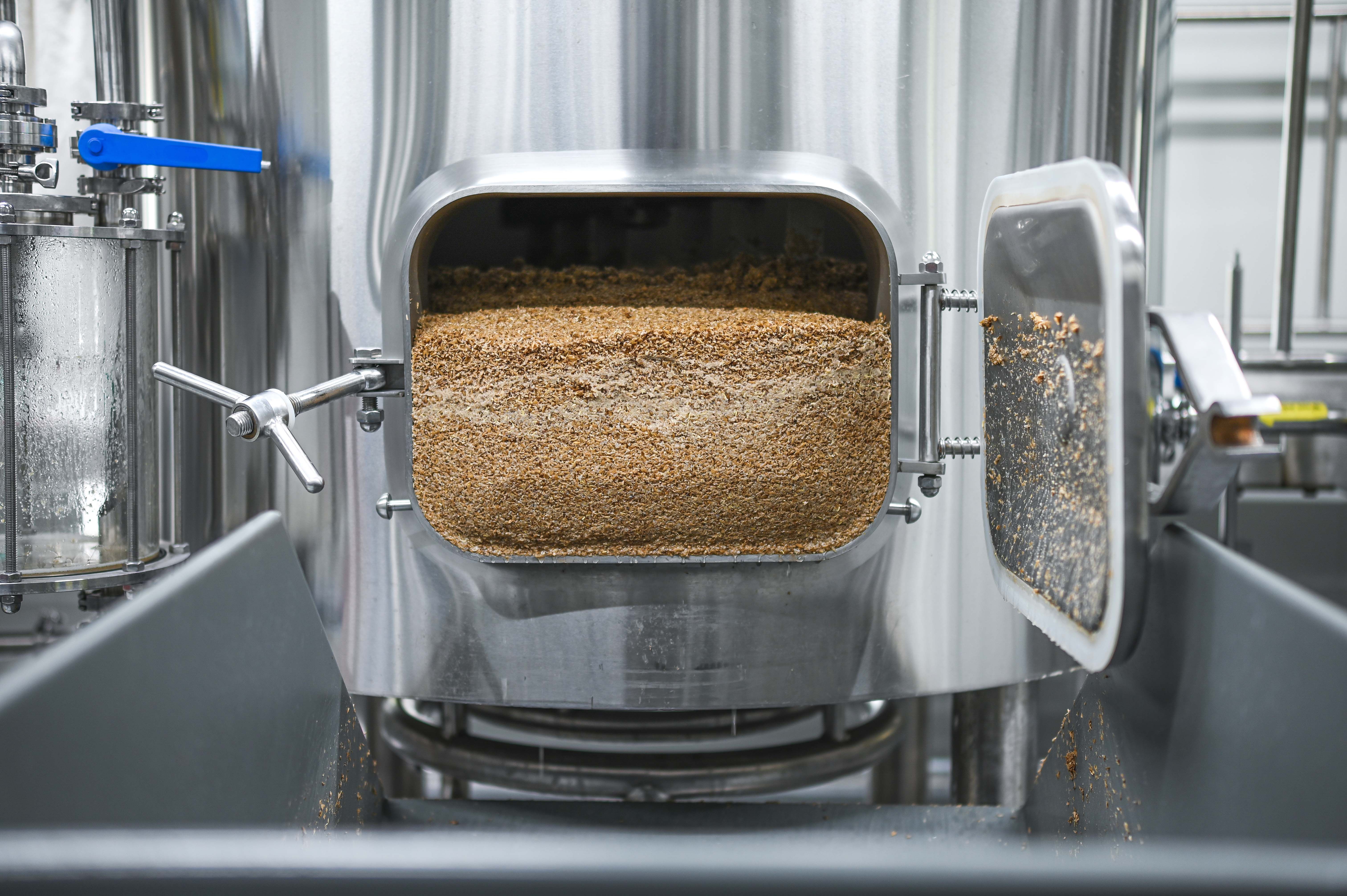 Geöffneter Braukessel mit Getreideresten in einer Brauerei.