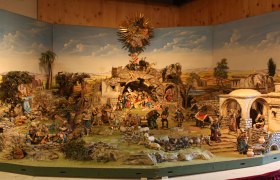 Alpenländische Krippe mit Figuren und Landschaft.