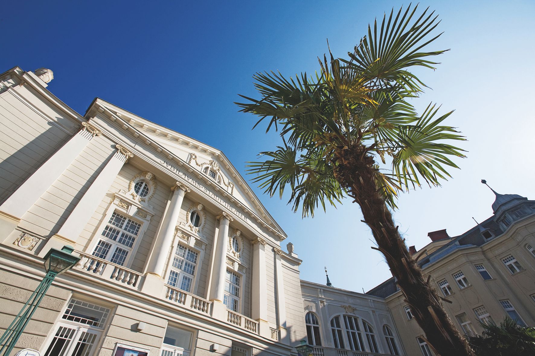 Das Stadttheater Baden bei Nacht, beleuchtet mit warmem Licht.