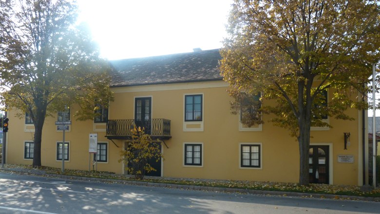 Gelbes Geb&auml;ude mit Balkon und B&auml;umen davor, Erzherzog Carl Haus und Napoleonmuseum in Deutsch-Wagram.