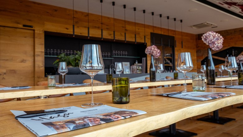 Innenansicht eines modernen Weindomizils mit gedeckten Tischen, Weingl&auml;sern und Dekoration.