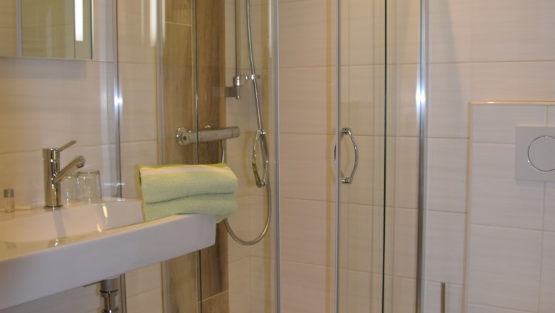 Modernes Badezimmer mit Duschkabine, Waschbecken und Toilette.