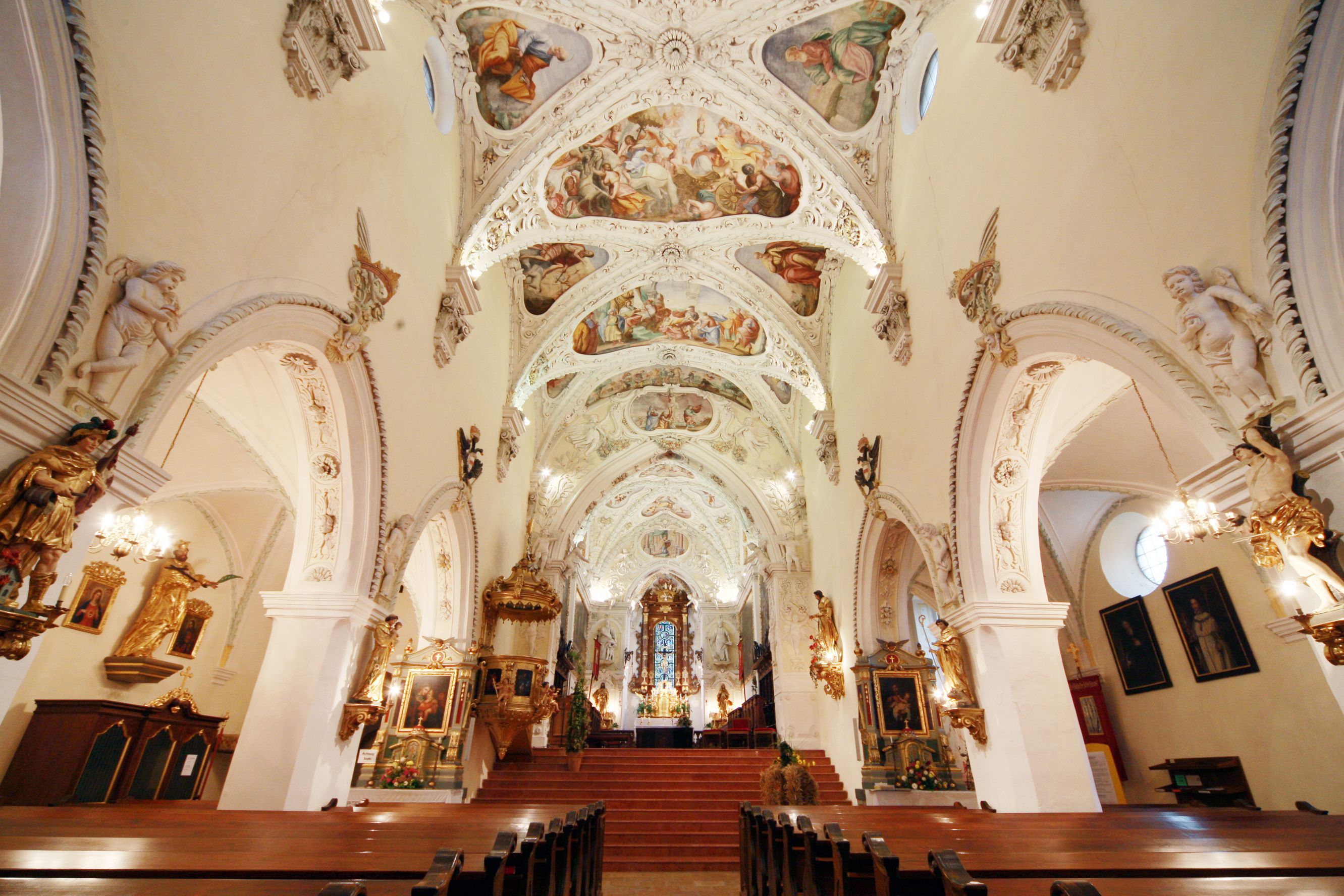 Innenansicht der Stiftskirche Ardagger mit kunstvoll bemalter Decke und reich verzierten Wänden.