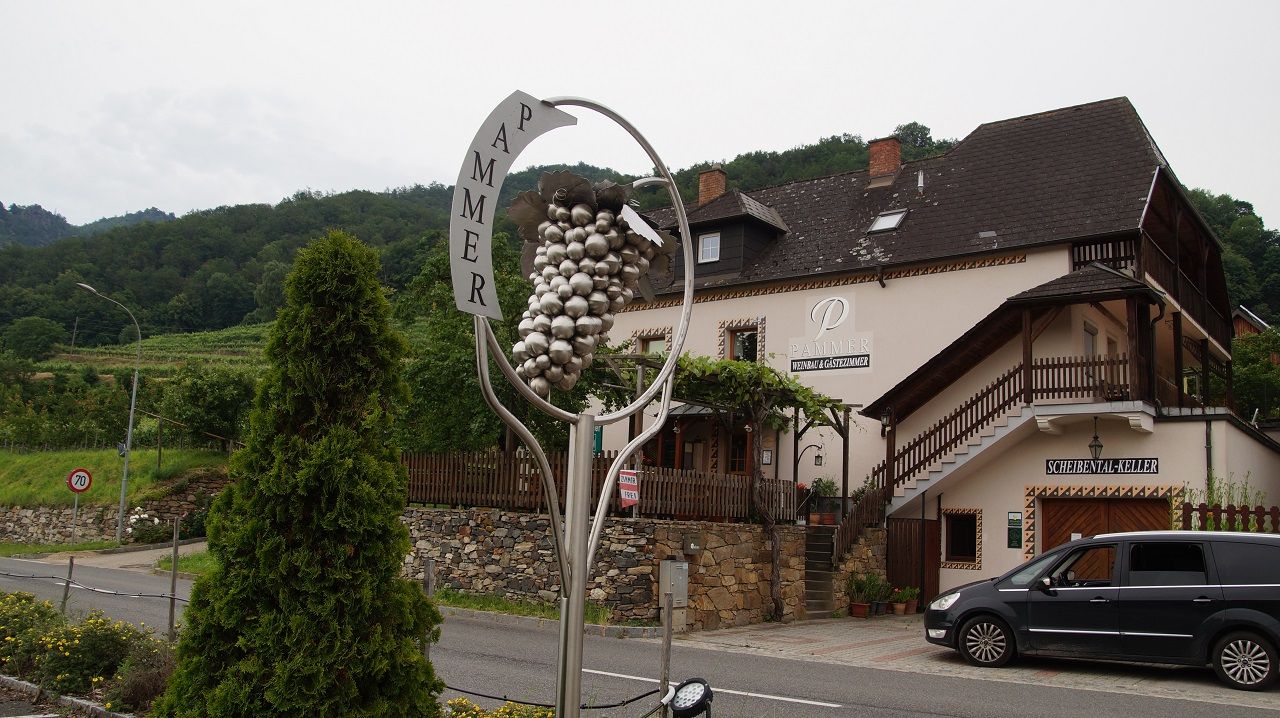 Weingut Pammer mit Traubenskulptur und Gebäude im Hintergrund.