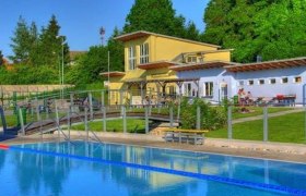 Freibad Altlengbach mit Schwimmbecken und Gebäude im Hintergrund.