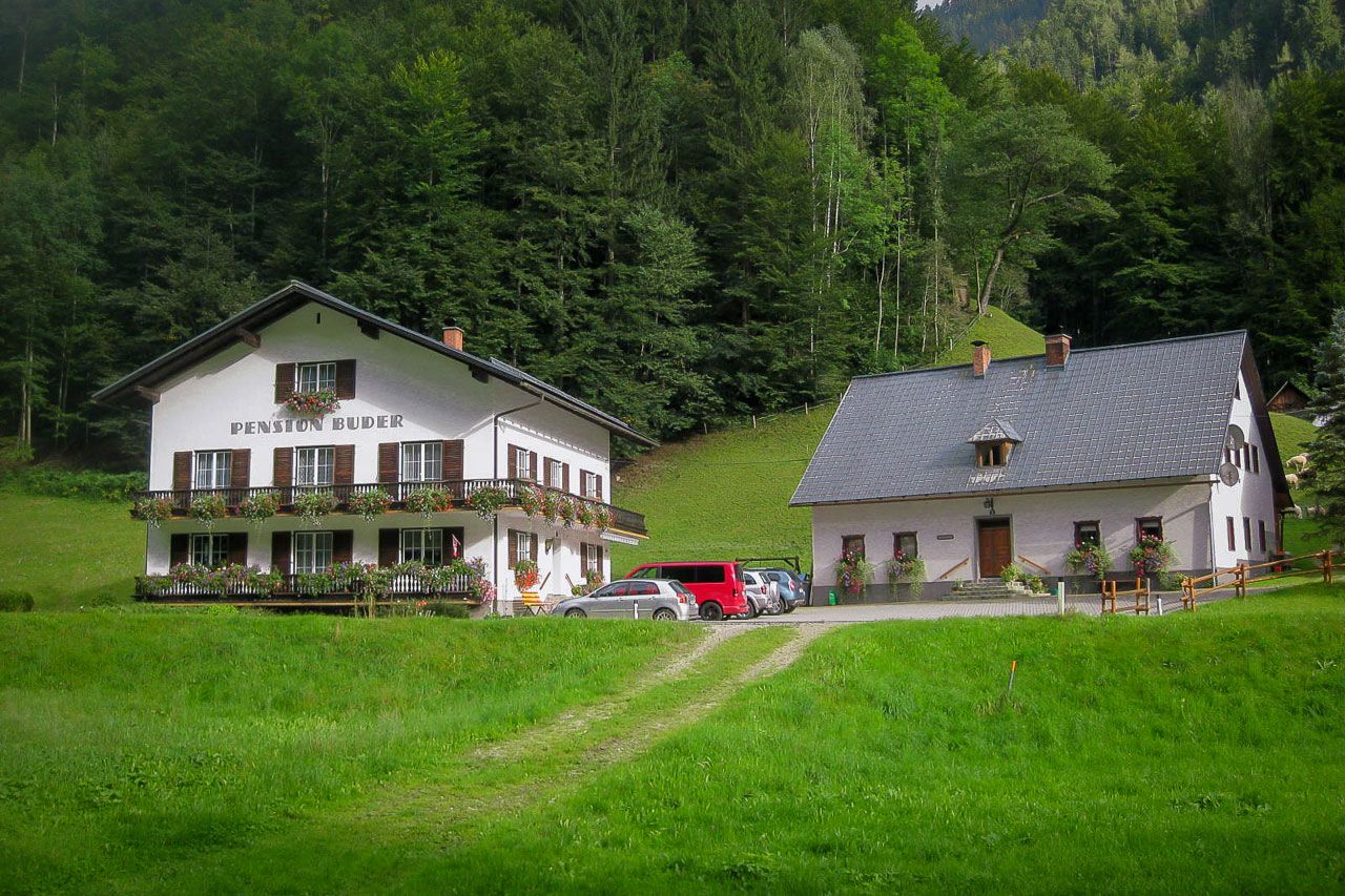 Zwei traditionelle Gebäude in einer grünen, bewaldeten Umgebung.