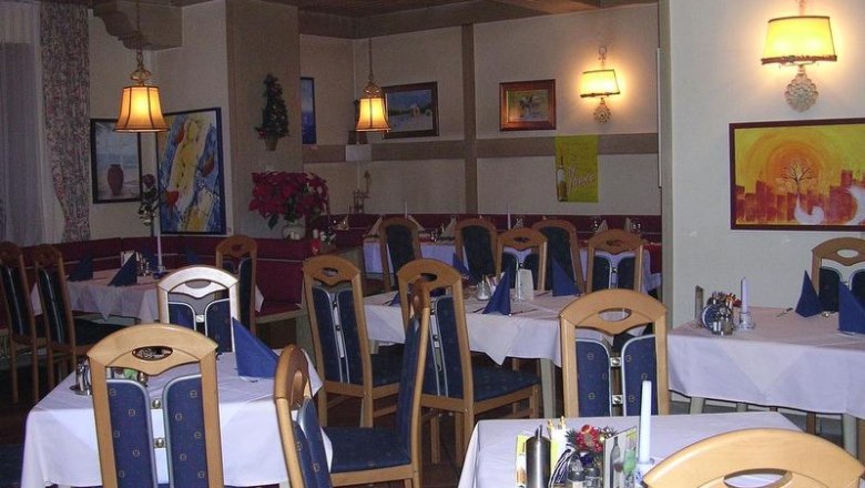 Ein gemütliches Restaurant mit Holzmöbeln, gedeckten Tischen und Wanddekorationen.