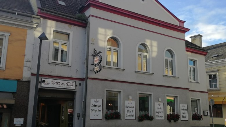 Gasthaus mit der Aufschrift 'Wirt am Eck' an einer Straßenecke.