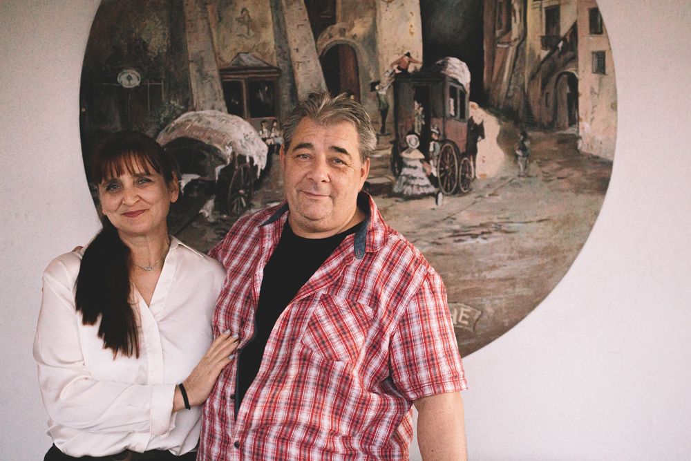 Ein Mann und eine Frau stehen vor einem Gemälde an der Wand.